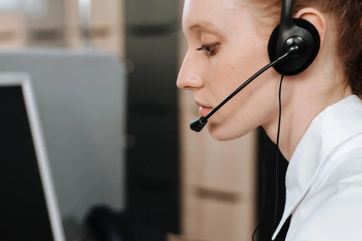 A support agent wearing a headset at her desk